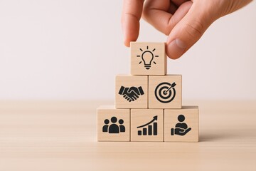 Concept of business strategy development, planning, and teamwork, presented by wooden blocks stacked in a pyramid