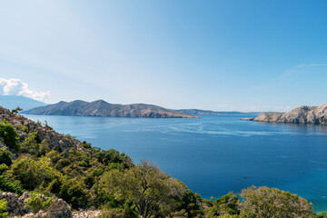 Scenic coastal landscape with rocky hills and clear blue sea under sunny sky. View of Prvic island, Croatia