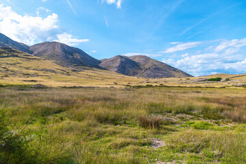 Fototapeta premium Serene mountain landscape with blue sky and rolling hills. Vela Luka beach, Krk island, Croatia