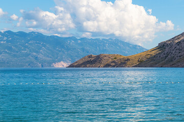 Tranquil seascape with mountain views under cloudy sky. Vela Luka beach, Krk island, Croatia