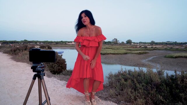 Mujer creadora de contenidos trabajando en un parque natural al atardecer.