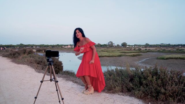 Mujer creadora de contenidos trabajando en un parque natural al atardecer.