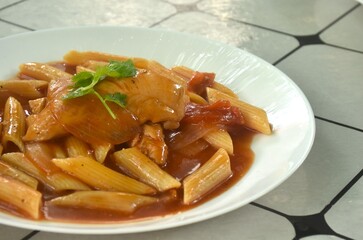 baking penne pasta topping slice chicken in sweet and sour gravy sauce on plate    