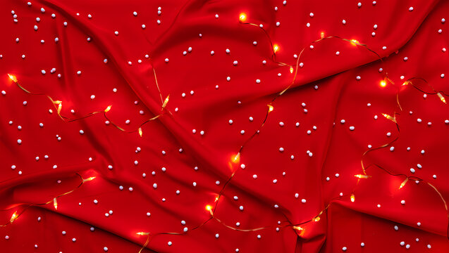 Red Fabric Background with Scattered White Dots and Twinkling Yellow String Lights textile texture