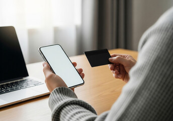 Effortlessly manage your finances and shop online using a smartphone and credit card next to a laptop, perfect for modern digital transactions and e-commerce convenience.