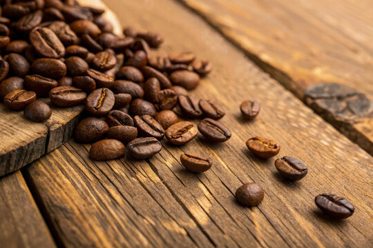 Roasted Coffee Beans Spilled on Rustic Wooden Table for Aromatic Brew
