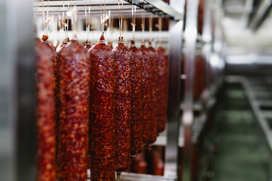 Smoked sausage production line in the factory - Powered by Adobe