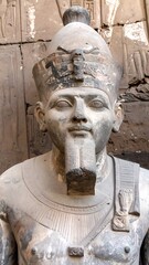 Ancient Egyptian pharaoh statue, weathered, with beard and headdress