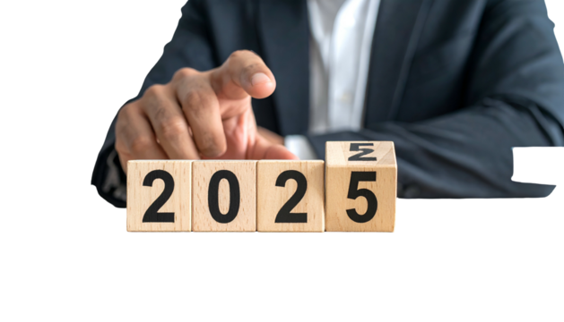 A person in a suit points to wooden blocks spelling out the year 2025