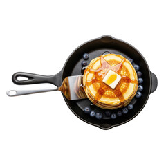 Overhead view of pancakes with butter and syrup in a cast iron skillet with blueberries