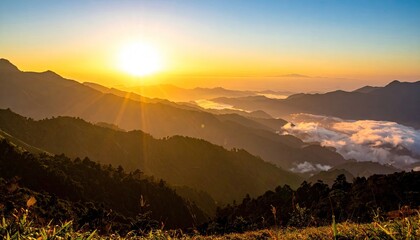 Sunrise Over Mountain Ranges With Golden Sun Rays Illuminating The Foggy Valleys Below And Silhouetted Trees In The Foreground