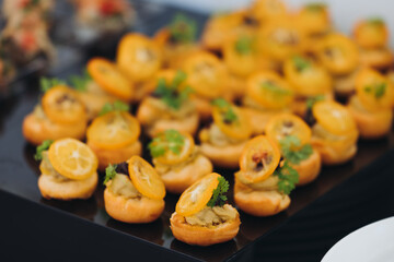 Decorated catering table, banquet with variety of different gourmet exquisite food snacks appetizers on corporate birthday party event or wedding celebration, canape, salad, delicatessen setting