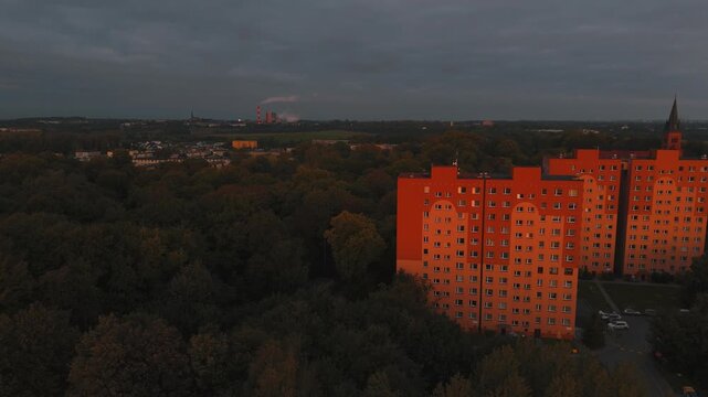 Ruch drona w prawo nad blokami z panoramą dalszych zabudowań.