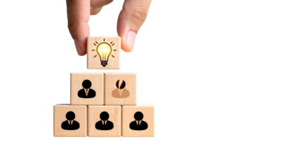 Hand places lightbulb block atop team blocks, forming pyramid on black