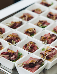 Decorated catering table, banquet with variety of different gourmet exquisite food snacks appetizers on corporate birthday party event or wedding celebration, canape, salad, delicatessen setting