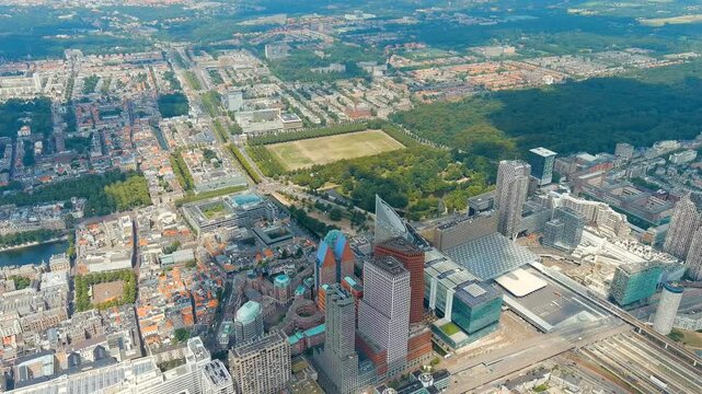 The Hague, Netherlands. Business center of The Hague. Large train station Den Haag Centraal. Cloudy weather. Summer day. Drone footage. Around the point