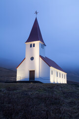 Quaint church in the coastal town of Vik, Iceland, on a foggy night 

