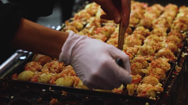 Takoyaki - popular Japanese Street Food, deep-fried dough octopus dumpling balls, variety of different traditional food snack selection in Osaka, Japan, street market with local vendor stalls cooking