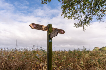 Wooden marker and direction sign on the Weavers Way, a rural walk in Norfolk