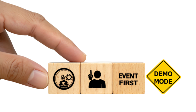 Hand placing wooden blocks with event related icons and text, plus a "Demo Mode" sign