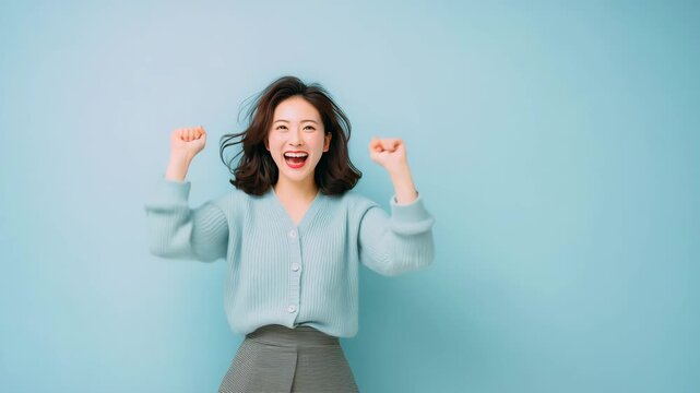 白背景で両手を上げて喜ぶ女性