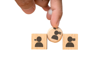 Hand placing person icon block among two others. Thematic of choice/selection