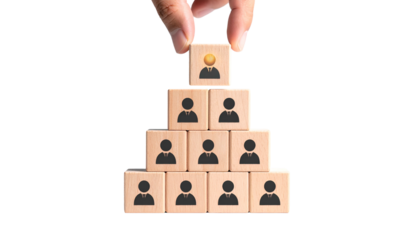 Hand placing a person-icon block atop a wooden pyramid of other person-icon blocks