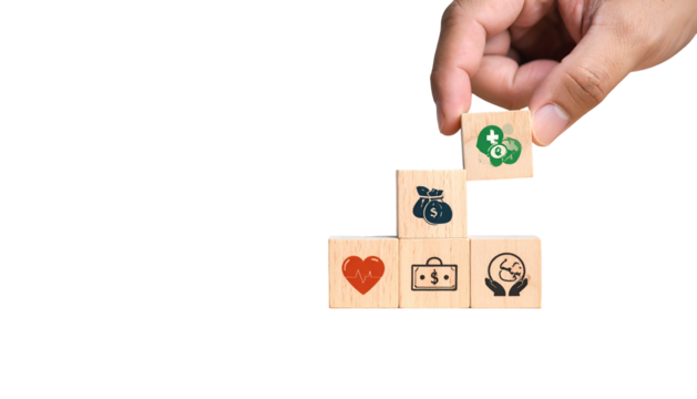 Hand placing health icon block atop a staircase of wealth, heart, and environment