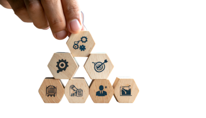 Hand building a wooden block pyramid with strategy icons, on black background