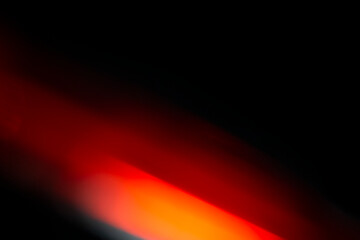Abstract motion blur of bright red and orange city street lights creating a dark, colorful bokeh fire effect