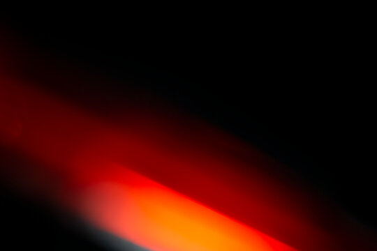 Abstract motion blur of bright red and orange city street lights creating a dark, colorful bokeh fire effect