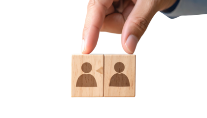 Hand placing blocks with people icons, symbolizing teamwork or interaction, against black