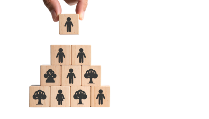 A hand places a person icon atop a wooden block pyramid; human symbols are visible