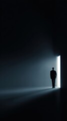 Obraz premium Person standing in doorway between darkness and light, metaphor for personal breakthrough,