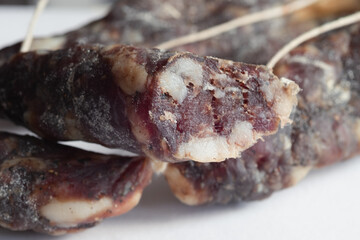Sliced ​​cured sausage, photographed up close, highlighting the meat's texture and intense color. Artisanal sausage. For culinary, editorial, or advertising projects related to traditional Italian pro
