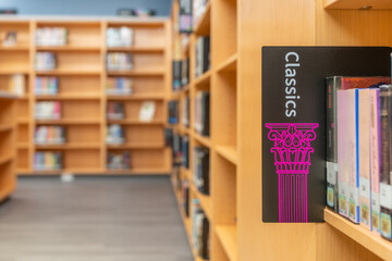 Photo of a Classics sign on a bookshelf in a library.