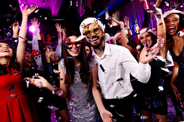 Funny wild party moment at a neon nightclub crowd dancing with glitter masks and confetti celebration with friends and music
