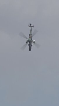 Vertical footage of a military helicopter performing combat flight maneuvers