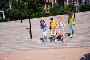 Fototapeta premium Dynamic group of young friends enjoying a sunny day outdoors, showcasing diversity and joyful companionship in an urban setting