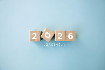 2026 loading concept with wooden blocks on blue background