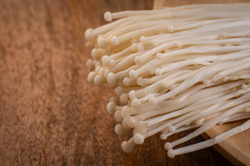 Fresh golden needle mushroom or enoki, enokitake Flammulina velutipes in wooden plate