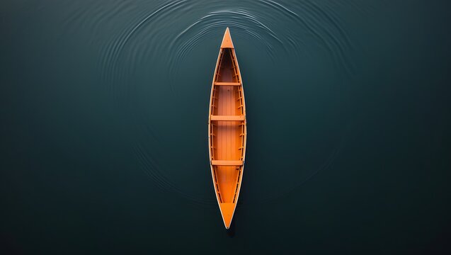 Aerial view of a person in a wooden canoe gliding across a calm dark blue lake