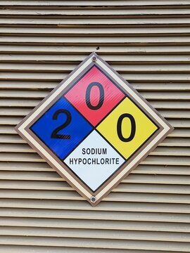 Diamond shaped NFPA panel identifying hazardous at public pool. Sodium hypochlorite