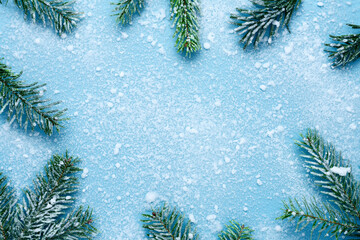 Frosty Christmas and New Year composition. Top view of green fir tree branches covered with snow on...
