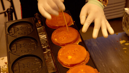 Vendor preparing gyeranppang, a popular street food snack, in a Korean market