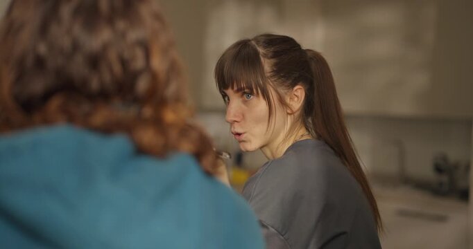 Two friends share a quiet moment in a softly lit living room, exploring thoughts and emotions in deep conversation