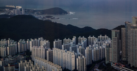 Busan city expanding across mountains and coastline with dense residential apartment buildings near the sea