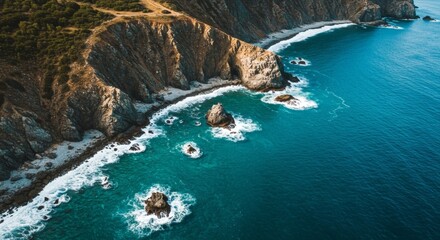 Drone view of coastline showing cliffs waves and clear blue water