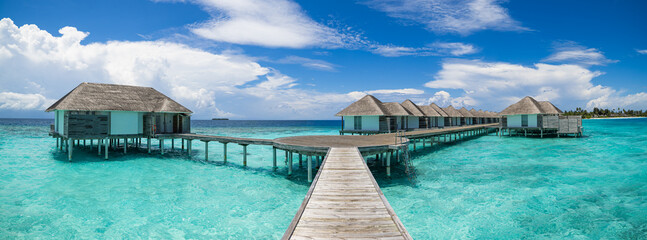 Luxury Maldives water villas. Relaxing sunny ocean lagoon, pristine sea bay blue sky calm water. Tranquil summer luxury tourism. Best popular resort view destination travel, wide angle panorama travel