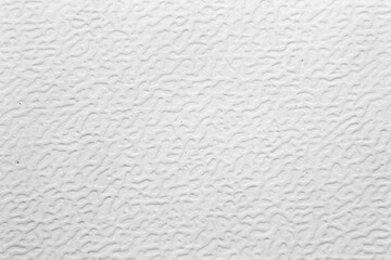 Macro shot of a white or light gray surface with a pronounced, irregular, wavy texture shagreen. A versatile, clean, and minimalist abstract background, ideal for design, imitation of plastic.